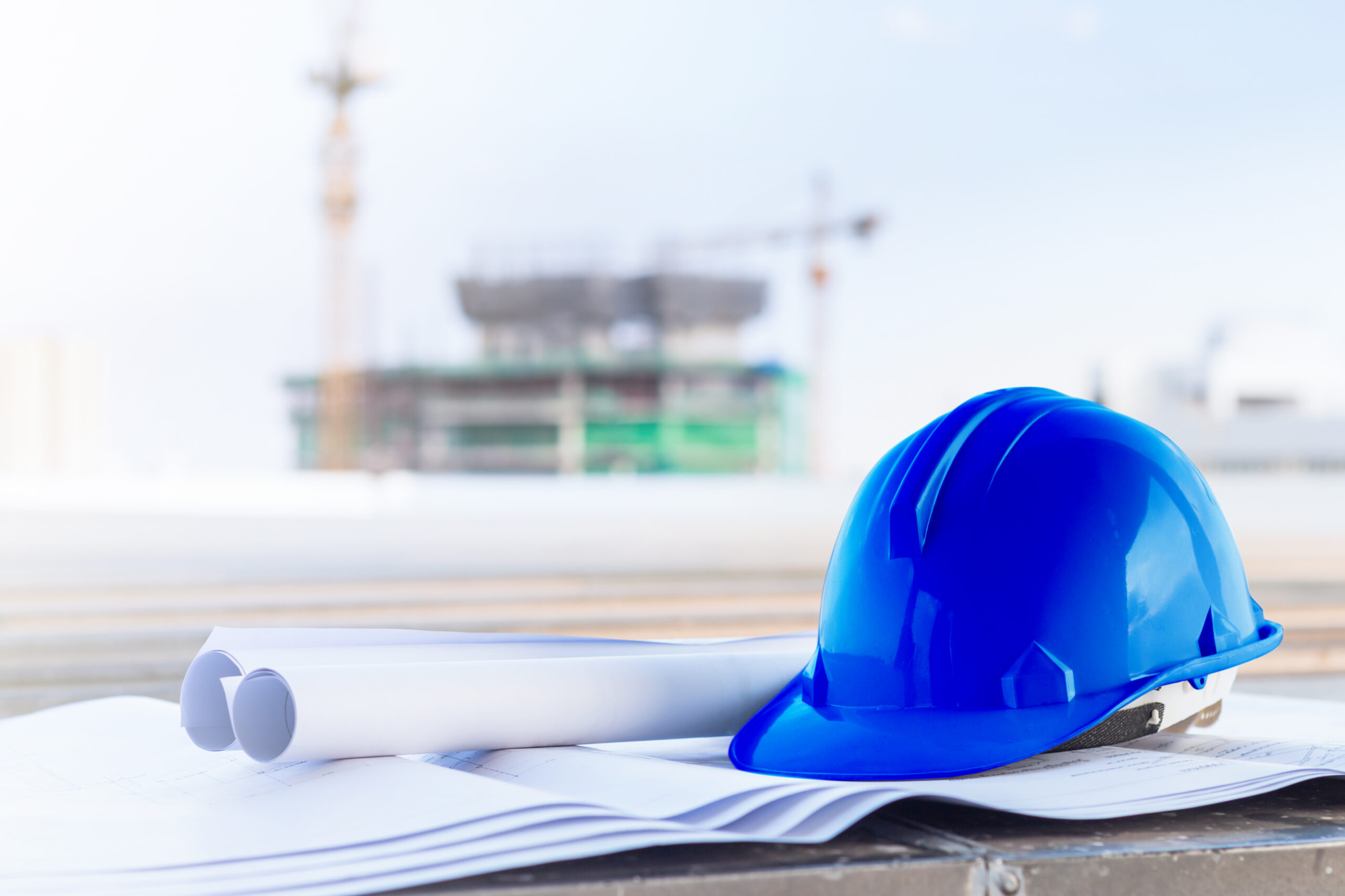 the blue safety helmet and the blueprint at construction site wi